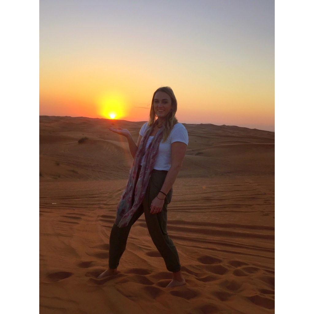 Girl holding hand under sunset on sand dunes